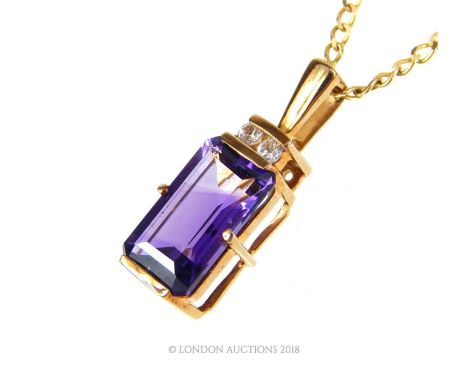A 9 ct yellow gold necklace, set with a rectangular, stepped cut amethyst (12 x 6 mm) and set above with two brilliant cut di