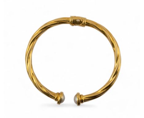 Italian, 1980s An 18 carat gold twist bangle with faux half pearl terminals. Approximate weight 17 grams