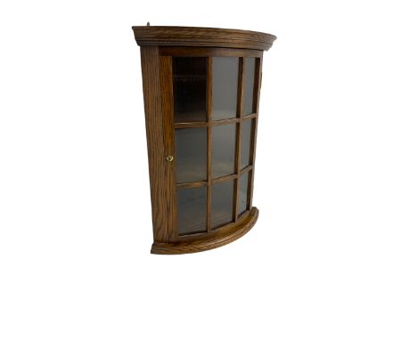 Oak bow-front corner unit, astragal glazed door enclosing two shelvesDimensions: Height:&nbsp;67cm&nbsp; Length/Width:&nbsp;5