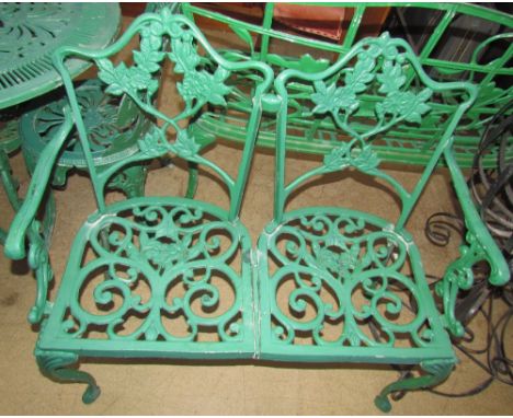 A two seater garden bench, painted green together with a table and four chairs and a three seater garden bench