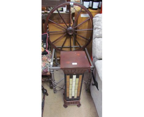 A ships wheel together with a metal coffee table and a floor lamp with multi-coloured glass panels