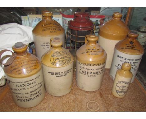A Pickup Bros Pontypridd stoneware flagon together with a collection of stoneware flagons including M Dutson, Swansea, Saxons