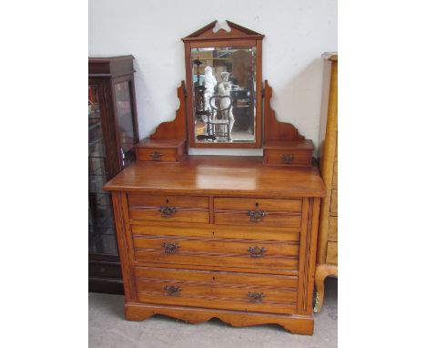 An Edwardian satin walnut dressing table, the rectangular mirror with an architectural pediment, the base with two short and 