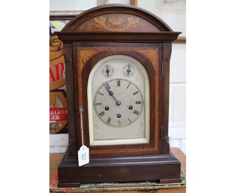AN EARLY 20TH CENTURY MAHOGANY CASED MANTLE CLOCK with decorative boxwood inlay to the arching case, the silvered dial with r
