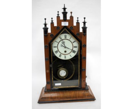A 19TH CENTURY WALNUT MANTLE CLOCK with castellated top and white painted dial with black painted Roman numerals, standing on