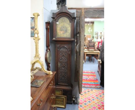 AN ANTIQUE OAK LONGCASE CLOCK the eight day movement with brass dial signed Thos Binks, Barningham, the later carved case wit