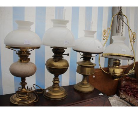 TWO BRASS OIL LAMPS with white glass shades together with a hanging lamp and a further table lamp in the form of an oil lamp 