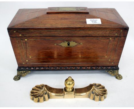 A VICTORIAN ROSEWOOD AND BRASS INLAID TEA CADDY of sarcophagus form with lion mask ring handles to either end cast brass paw 