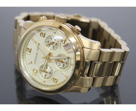 A GILT CHRONOGRAPH WRISTWATCH by Michael Kors, the dial with Arabic numerals and three subsidiary dials and date aperture, 3.