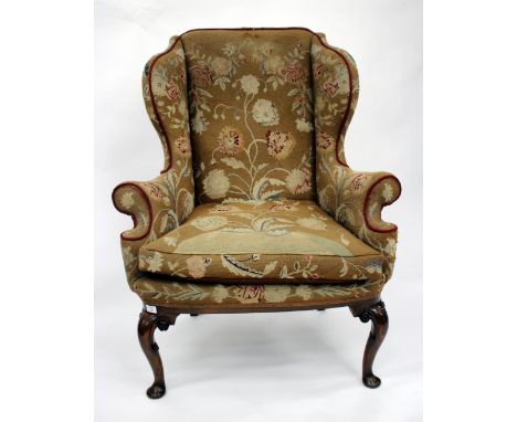 AN ANTIQUE GEORGIAN STYLE WING BACK ARMCHAIR with walnut scrolling feet and tapestry upholstery 88cm wide