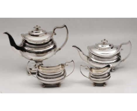 A GEORGE III SILVER FOUR PIECE TEA SET with two different tea pots, each with gadrooned borders, engraved decoration and stan