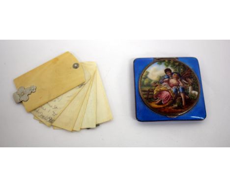 A VICTORIAN OR EDWARDIAN IVORY NOTEPAD together with an enamalled power compact, the lid decorated with a scene of a shepherd