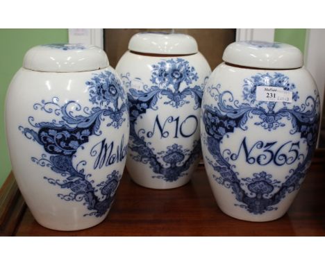 A SET OF THREE CROWN DEVON BLUE AND WHITE CERAMIC DRUG JARS and covers with transfer printed cartouche motif 58cm high 