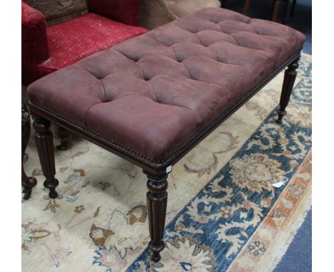 A SUEDE BUTTON UPHOLSTERED DRESSING STOOL standing on ring turned and fluted legs 107cm wide 