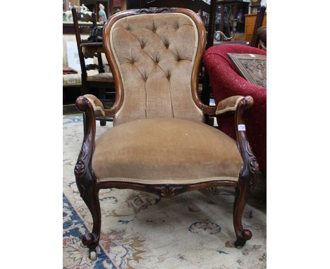 A VICTORIAN WALNUT OPEN ARMCHAIR with shaped overstuffed button upholstered back, overstuffed upholstered arms and seat, scro