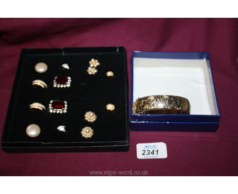 A box containing seven pairs of earrings and a gold coloured bangle unmarked