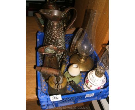 A quantity of copper and brass items including two jugs, blow lamp, bell, oil lamp, and a china oil lamp, etc