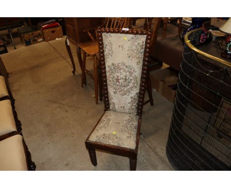 A 19th century upholstered child's chair raised on bobbin turned supports