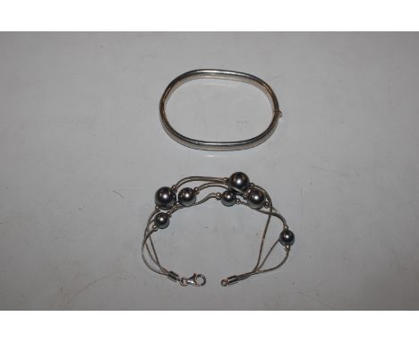 A Sterling silver bangle and Sterling silver and pearl three strand bracelet