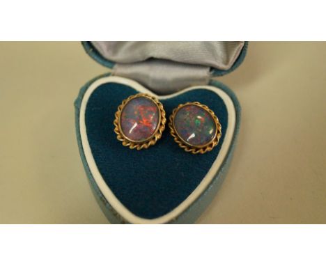 A pair of unmarked oval doublet opal ear studs.