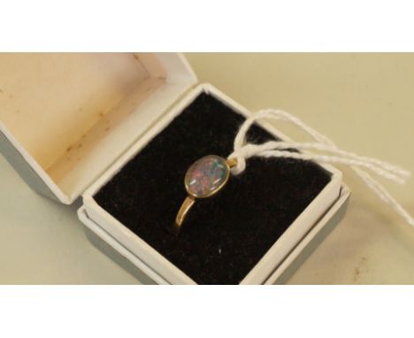 A gold oval cabochon opal doublet ring, 1.1g total weight. Condition Report: Note hallmarks present but difficult to read.