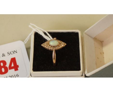 An Edwardian 15ct gold cabochon opal ring, the oval stone surrounded by diamond chips, in a marquis setting.