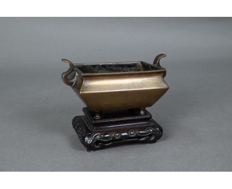 A 19th century Chinese censer or incense burner, late Qing dynasty, the tapered compressed rectangular body with two scrollin