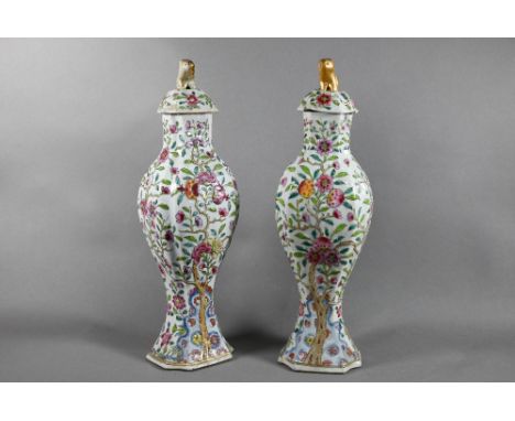 A pair of 18th century Chinese famille rose garniture vases and covers with gilded animal finials, the vases of moulded balus