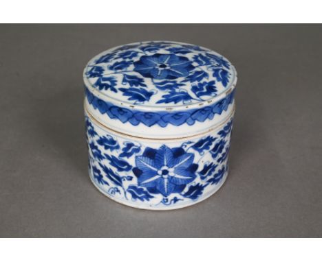 An 18th century Chinese blue and white cylindrical jar/caddy and cover painted in underglaze blue with blossoming lotus scrol