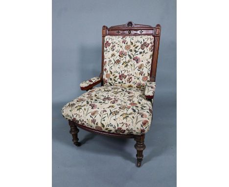 A late 19th/20th century walnut framed and moulded open armchair with autumn leaf and floral pattern upholstery, raised on ce