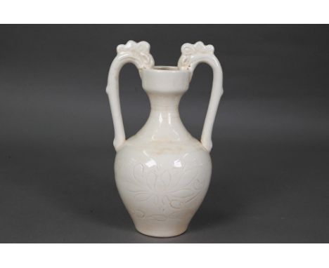 A Chinese Tang style white glazed 'amphora' vase, the looping handles with dragon head terminals biting the rim, decorated wi