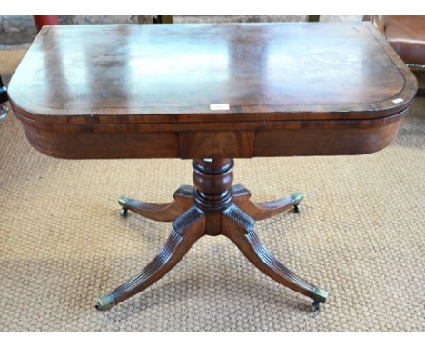 A Victorian ebony-strung mahogany card table, the fold-over top revealing a storage well, raised on a baluster turned support