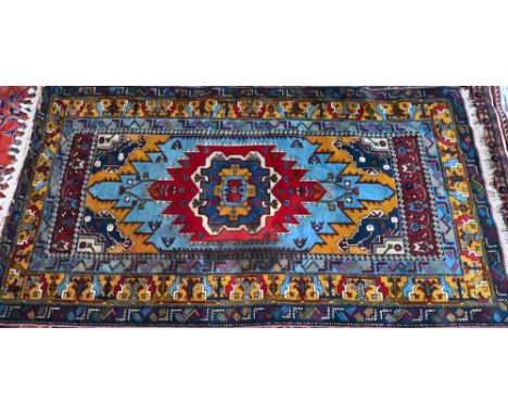 A Turkish light blue ground rug with centred with gold ground lozenge design, 234 cm x 132 cm good even pile, clean