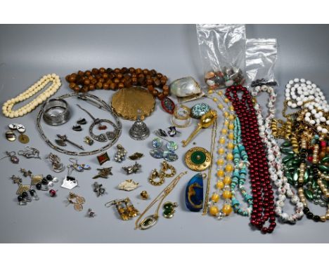 A collection of jewellery including beads, necklaces, earrings, brooches, compact, silver napkin ring etc 