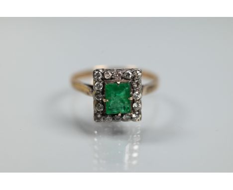 An emerald and diamond cluster ring, the central rectangular cut emerald with diamond surround, unmarked yellow and white met