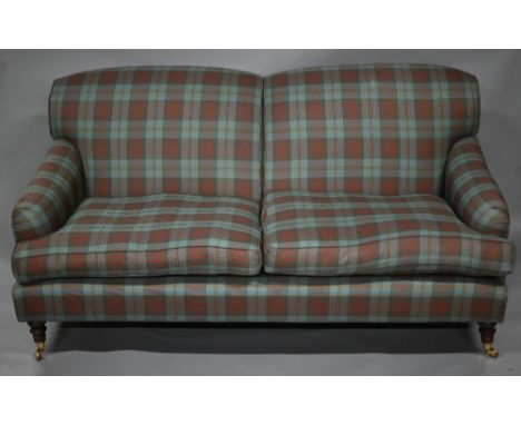 A contemporary pale green / red chesk patterned two seat sofa, on turned mahogany legs to brass castors, 184 cm w x 100 cm x 