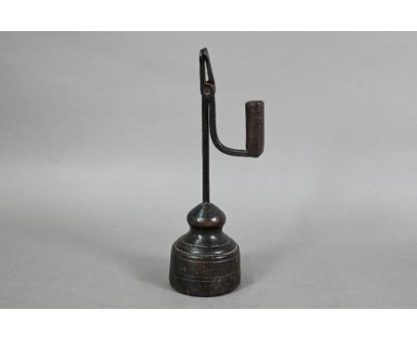An 18th century wrought iron pivoting rush light holder, raised on a wood block base, 28 cm h, evidence of old wormHinge pin 