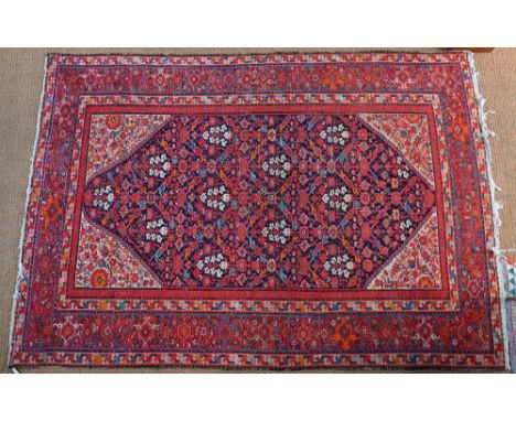 An antique Persian Hamadan carpet, centred by a blue ground floral lozenge on red ground, 305 cm x 208 cm, even low pile, end