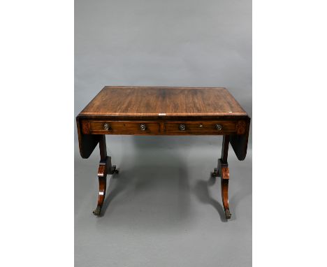 A Georgian cross-banded and inlaid rosewood sofa table, the drop leaf top over two frieze drawers and opposing dummy drawers,