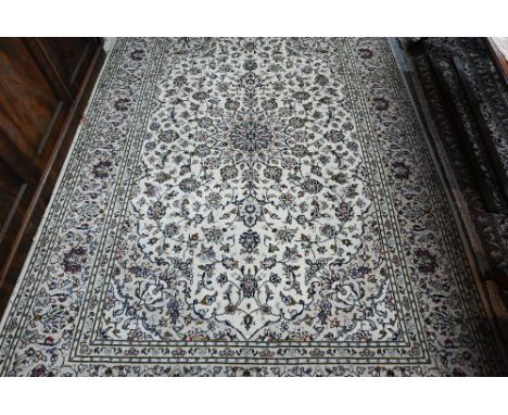 A contemporary Persian Kashan carpet, the cream ground centred by floral medallion and training floral branches, 292 cm x 200