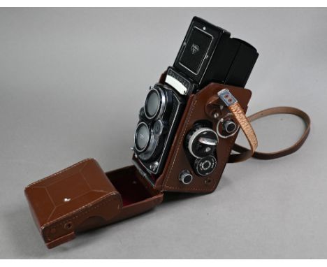 A Franke & Heidecke Rolleiflex twin-lens reflex camera with Planar 1:3.5 f=75 mm Zeiss and Heidosmat 1:2.8/75 lenses, in leat
