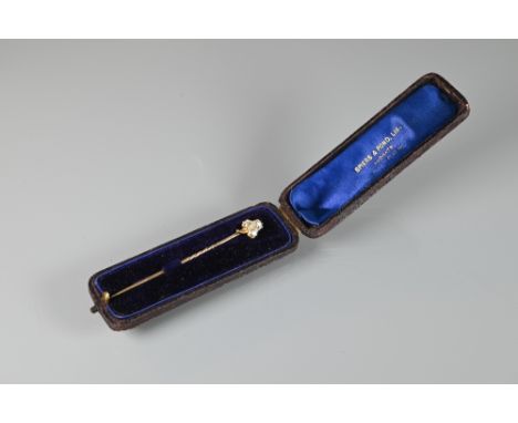 A trefoil diamond set stick pin in fitted case, 6.8 cm long screws off stick not bent, claws intact, UV flouescence high on o