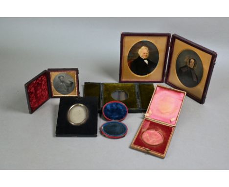 A Victorian pair of painted-over photographic portraits of an elderly couple in folding pocket-case, to/w an Ambrotype portra
