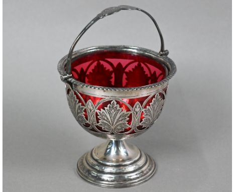 A Victorian silver sucrier with swing handle and foliate-pierced and engraved decoration, on flared foot, with cranberry glas
