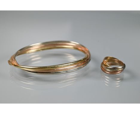 A tri-coloured metal oval half-hinged bangle, unmarked, and a 9ct tri-coloured ring, size K, approx 12.8g (2)
