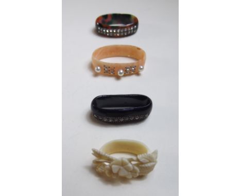 Three bakelite style scarf rings and a simulated ivory one