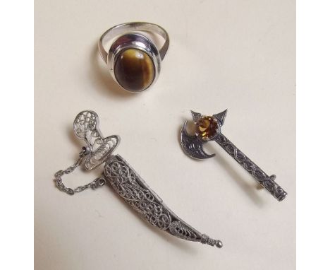 A silver Celtic/Scottish brooch in form of an axe with a silver tigers eye ring and a silver filigree sword and scabbard broo