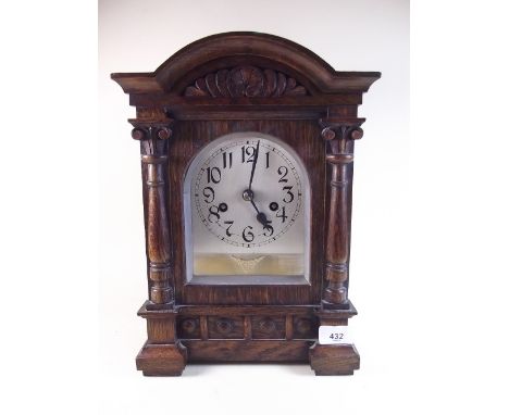 A oak cased architectural style chiming mantel clock with carved decoration