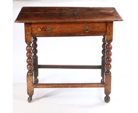 A late 17th Century fruitwood side table, the rectangular top above a long frieze drawer and bobbin carved supports united by