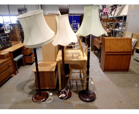 Three wooden standard lamps with shades, one damaged. All electrical items in this lot have been PAT tested for safety and ha